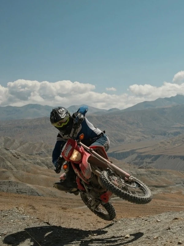 Professional motorbike rider performing a small stunt in Upper Mustang